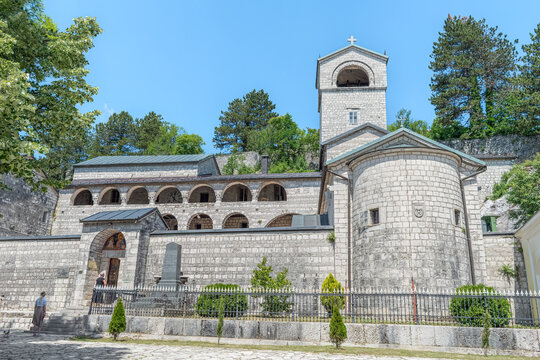 The main entrance to Cetinje Monastery with religious frescoes above the door and a stone bell tower. This 18th-century Orthodox complex is a spiritual heart of Montenegro. Cetinje, June 20, 2021