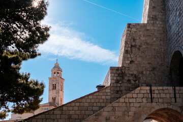 Obraz premium Exploring ancient stone structures and a stunning bell tower against a vibrant blue sky in a historic town square
