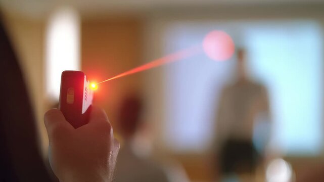 Hand with laser pointer at presentation or lecture, pointing to screen in conference room