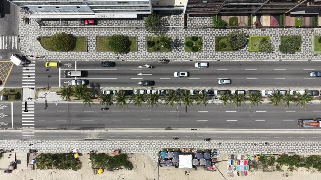 Drone top-down view of Copacabana coastal road with traffic and palm trees, Rio de Janeiro