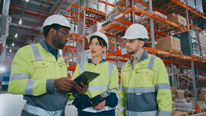 African American male worker explaining task and using tablet device. Working in warehouse. Serious...