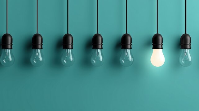 吊り下げられた複数の電球のうち一つだけが点灯している状態。アイデアや独創性を表現するビジネスやプレゼンテーション向けのイメージ素材