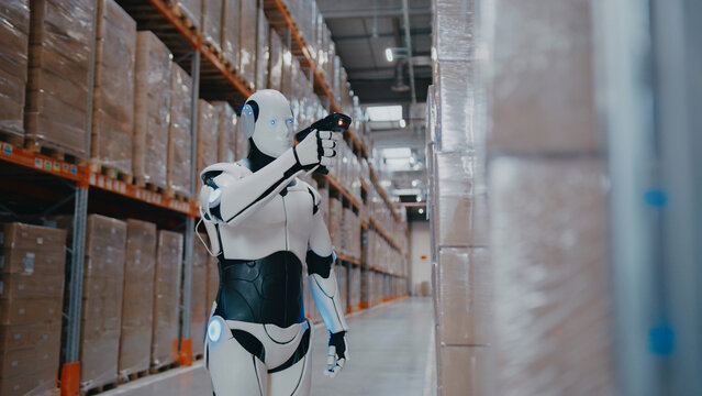 AI-powered robot scanning product labels with device while standing near stacked boxes inside large warehouse. Updating stock records or verifying shipments in automated logistics control system.
