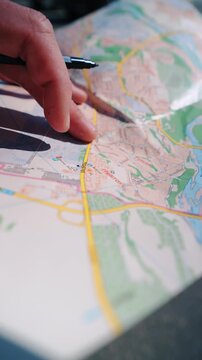 Close up of traveler marking destination on a paper map