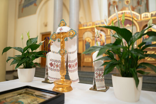Golden altar cross with embroidered rushnyk and peace lilies