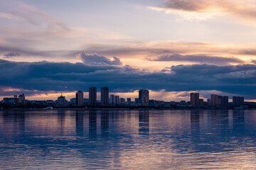 Fototapeta premium Heihe city skyline glowing at sunset, reflected on the calm Amur River surface