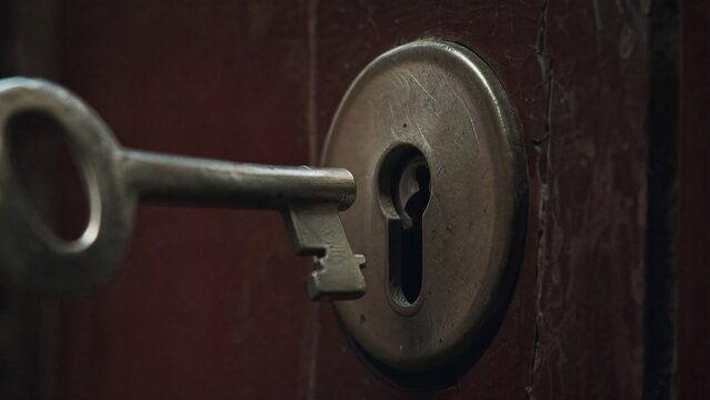 misaligned. A metal key slightly misaligned with a door lock's keyhole in dim light. product launch decks, UI/UX mockups, designed for data visualization dashboards and holographic UIs.