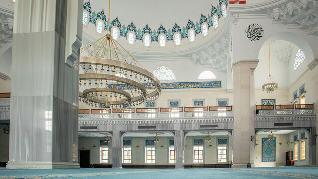 The interior view highlights the transition from the main prayer hall to the side aisles. Decorative arches frame the area, enhancing the space's cultural features.