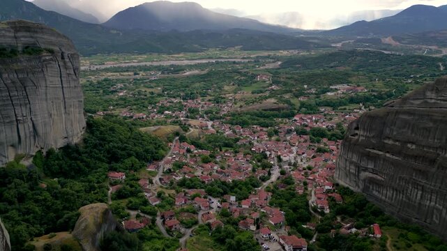 Aerial Flight Moving Up Over Rocks in Meteora, Kalambaka, Greece. Greek Village Lush Landscape Mountains Churches Wide