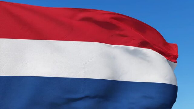 Dutch flag waving in the wind with blue sky background