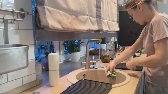 Kitchen hood filters being washed in sink removing grease and dirt. Cleaning ventilation system for hygiene and maintenance.