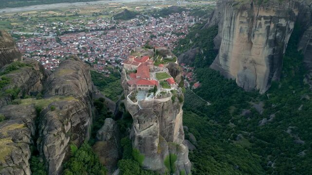 Epic Wide View Aerial Monastery of Holy Trinity Sunset Long Flight Counter Clockwise in Meteora, Greece. Church on Narrow Mountain Rock Landscape