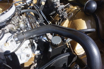 Fototapeta premium Detailed view of a classic vintage vehicle engine bay featuring several polished and customized components