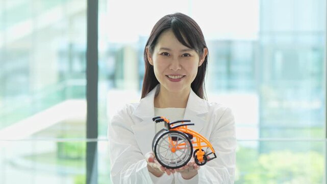 車椅子の模型を持つ医療関係者