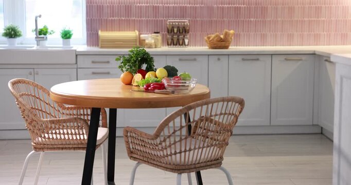 Fresh vegetables and fruits on wooden table in kitchen, camera moving down