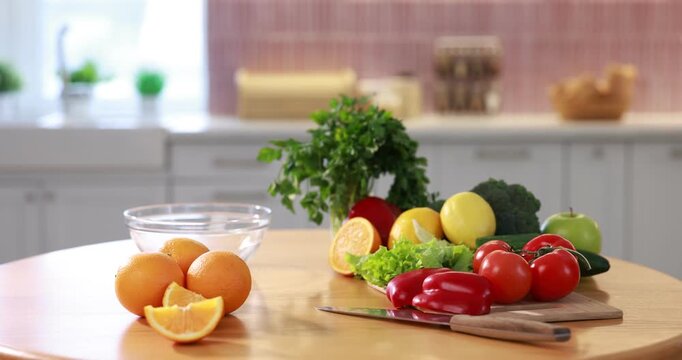Fresh vegetables and fruits on wooden table in kitchen, camera moving in
