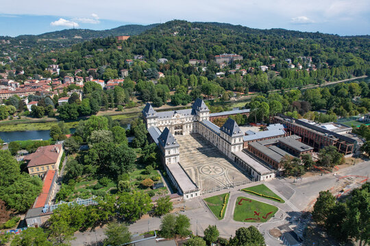 Aerial view of Castello del Valentino with its grand courtyard, surrounded by lush greenery and the Po river under a clear sky Torino, Piemonte, Italy.