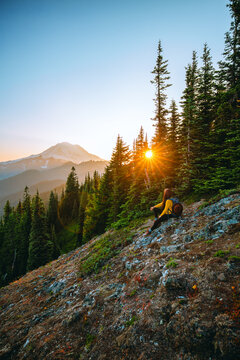 Woman enjoying sunset view of Mount Rainier on Naches Peak Trail in Mount Rainier National Park