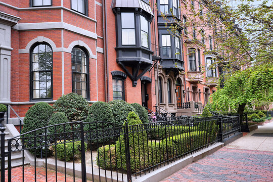 Street with elegant row of townhouses with front gardens