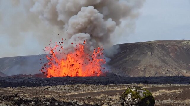 Volcanic eruption with glowing orange lava splashing and thick smoke rising from a rugged, barren landscape under a grey sky