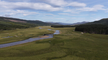 Fototapeta premium Aerial View of a Winding River and Bridge in Scottish Highlands