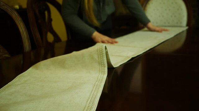 A Woman Sets Down a Dining Room Runner.