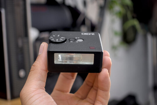 Zapopan Jalisco, Mexico - May 14, 2026: Hand holding compact camera flash godox IM30, camera flash concept