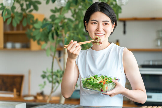 A young woman in sportswear eating a diet menu.