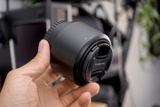 Zapopan Jalisco, Mexico - May 14, 2025: Hand holding Yongnuo lens with LH-52 T hood, lenshood concept