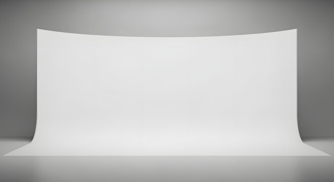 Professional empty photography studio setup featuring a seamless curved white cyclorama backdrop with soft overhead lighting for product mockup presentations