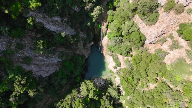 Top Down Aerial View of Swimmers in Natural Pool Below Polylimnio Waterfall in Green Rocky Canyon, Peloponnese Greece