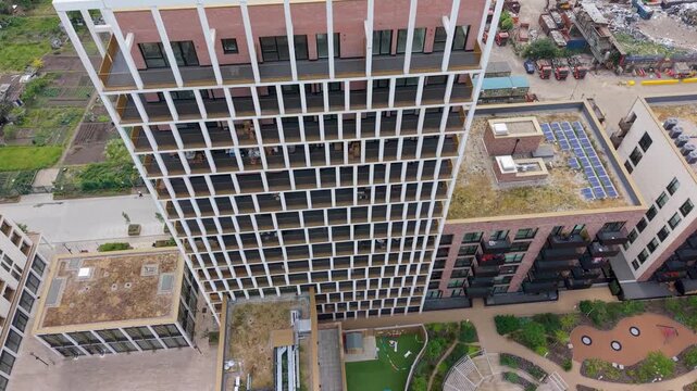 Wigeon Heights tower block drone push-in with tilt down from frontal view to top-down, finishing above the geometric grid facade and rooftops, highlighting modern residential architecture.