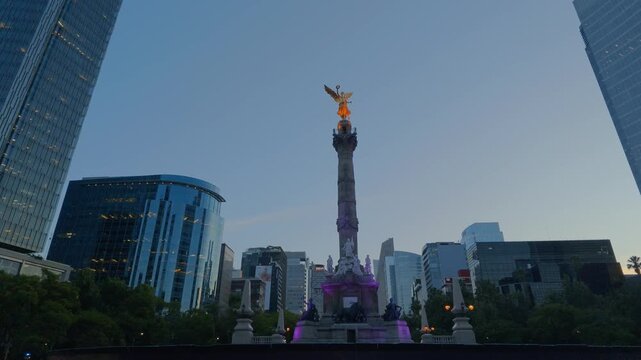 &Aacute;ngel de la Independencia brillando al amanecer con edificios corporativos de Ciudad de M&eacute;xico