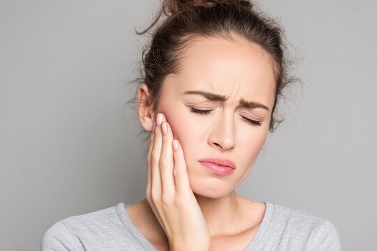 a person with a swollen face holding his cheek because of a toothache