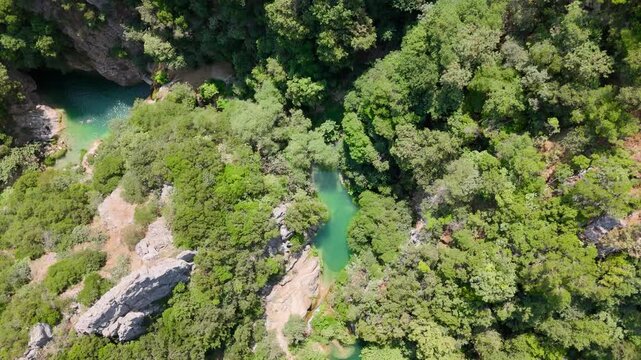 Top Down Drone View of Polylimnio Natural Pools and Waterfall Hidden in Dense Forest Canyon in Messinia, Greece