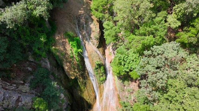 Aerial Drone View of Polylimnio Waterfall Cascades and Emerald Natural Pools Hidden in Dense Forest, Messinia, Greece