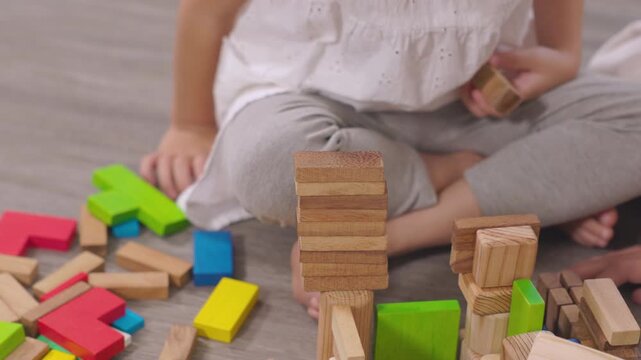 Happy children play and learn, education, homeschool little girl create wooden toy block build the house, improving intelligence and knowledge with mother, supporting emotional quotient creativity