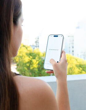 Mujer abriendo aplicaci&oacute;n de inteligencia artificial en su tel&eacute;fono m&oacute;vil, leyendo pregunta inicial de llamado a la acci&oacute;n