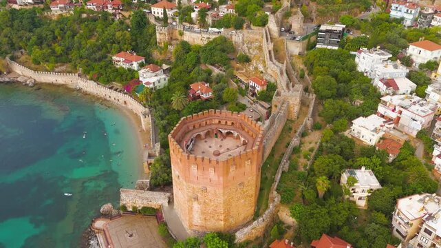 Alanya, Turkey. Kizilkule Red Tower, octagonal Seljuk fortress with red-brick walls and crenellated terrace commanding the turquoise harbor, aerial summer view. Aerial View, MasterShots, Rocket