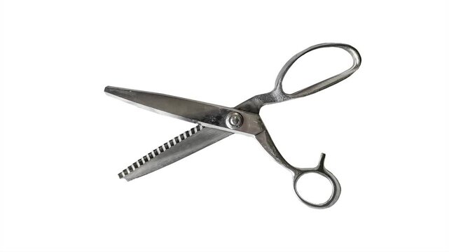 Stop motion animation showing a pair of fabric cutting scissors opening and closing their blades while moving smoothly from left to right in a continuous loop.