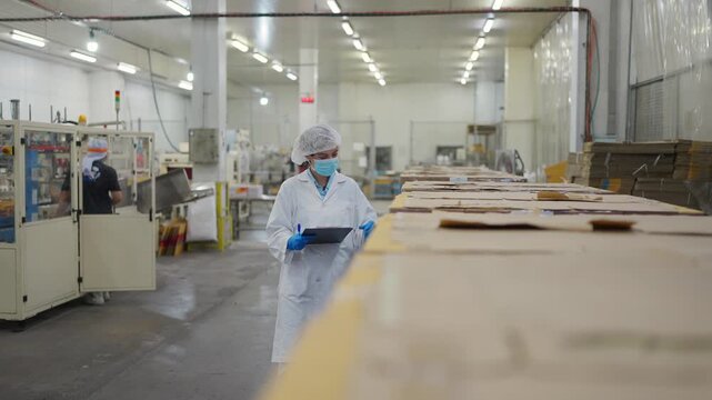 Factory Inspection: Amidst a state-of-the-art production line, a dedicated worker, equipped with protective gear, meticulously inspects the manufacturing process, symbolizing diligent quality control.