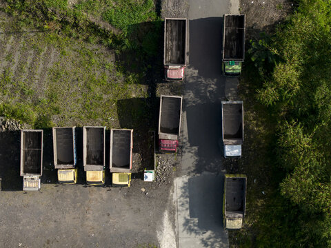 Aerial view of empty dump trucks parked at the Tambang Pasir Merapi Kali Gendol Sand Mine in Kecamatan Cangkringan, Daerah Istimewa Yogya, Indonesia.