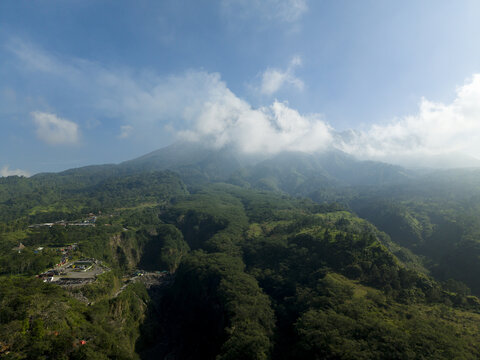 Aerial view of Tambang Pasir Merapi Kali Gendol Sand Mine and lush slopes of Mount Merapi under a blue sky Kecamatan Cangkringan, Daerah Istimewa Yogya, Indonesia.