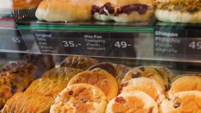Assorted Japanese and European Breads Displayed in a Modern Bakery Case