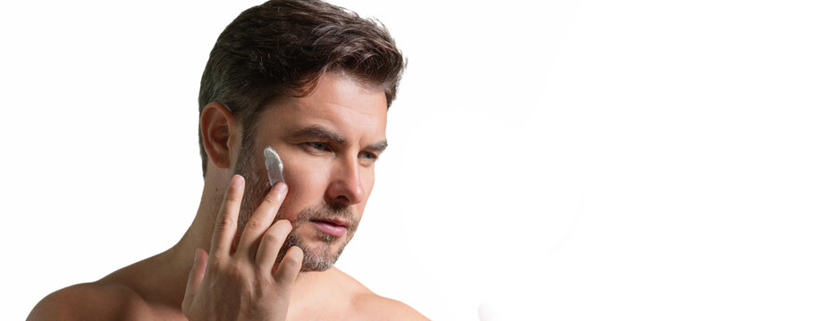 Mens beauty cosmetics, male beauty and skincare. Morning healthcare and hygiene for man. Perfect beauty skin. Handsome millennial man after shower apply facial cream or mask on skin. Wide banner.