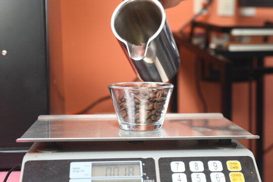 digital switcher weighing the exact coffee quantity for tasting
