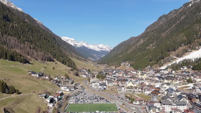 Mountain Village Of Ischgl Between Steep Forested Slopes In Paznaun Valley Of Tyrol, Austria. aerial pullback shot