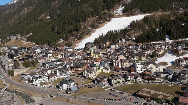 Green-spired Church And Traditional Hotels In Ski Resort Town Of Ischgl In Paznaun Valley Of Tyrol, Austria. aerial orbiting shot