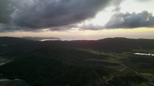 Panoramic aerial drone shot of Catanduanes, Bicol, Philippines with mountain terrain, coastal horizon, and dramatic sunrise clouds
