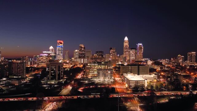 A 4k drone Timelapse tracking into the metropolitan city of Charlotte, North Carolina at sunset, dusk with heavy traffic and cars zipping by in the foreground
